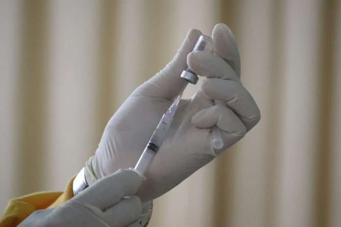 Επαγγελματίας υγείας προετοιμάζει ένεση σε κλινικό περιβάλλον